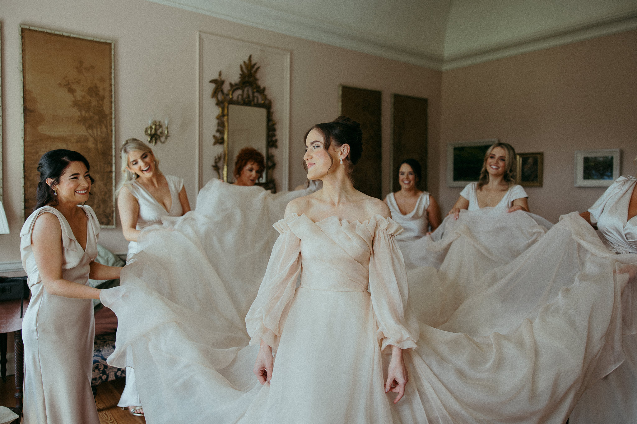 Bride and Bridesmaids holding her dress